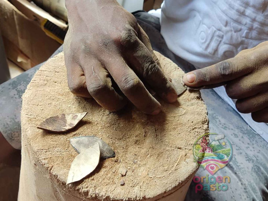 Manos de un artesano de Tumaco trabajando una pieza artesanal elaborada en Nariño