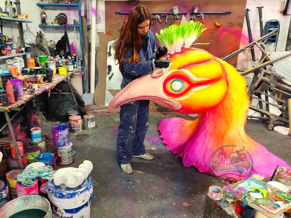 Visita a un taller del Carnaval de Negros y Blancos donde una artesana termina una pieza de una carroza en Pasto